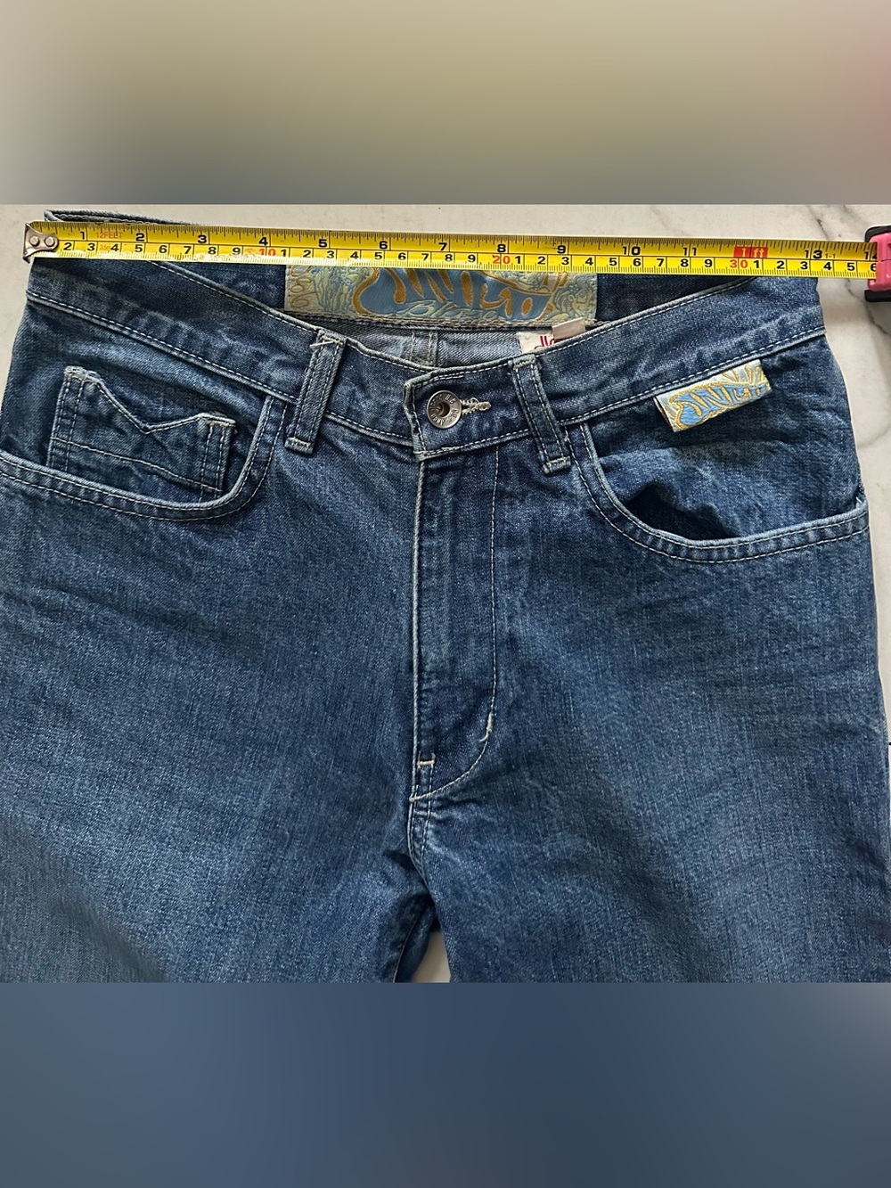 JNCO Juniors Blue Wide-Flare Jeans with unique pocket and stitching detail.